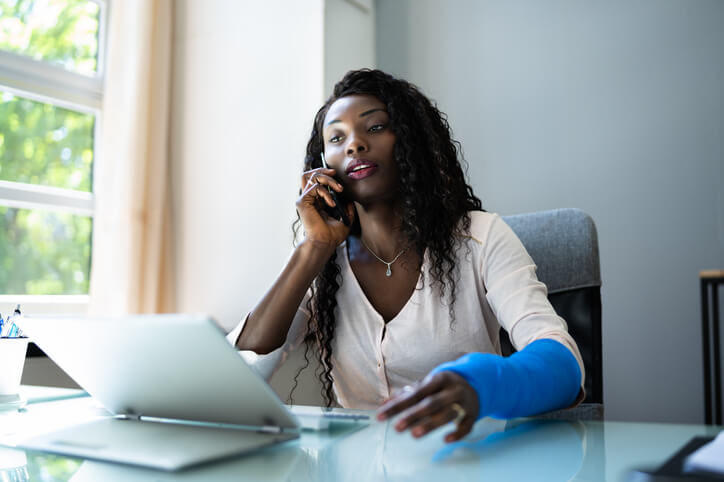 Injured woman on the phone and computer