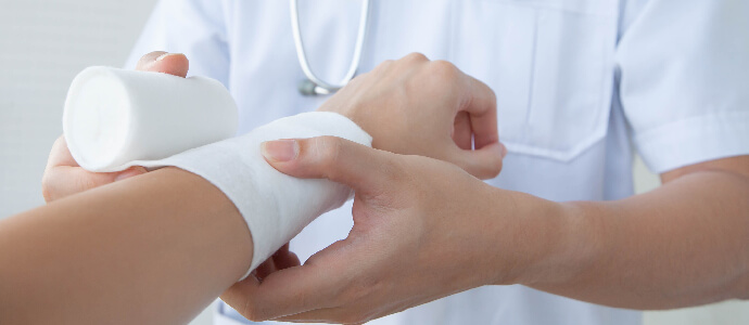 Doctor wrapping patient's burn injury with gauze