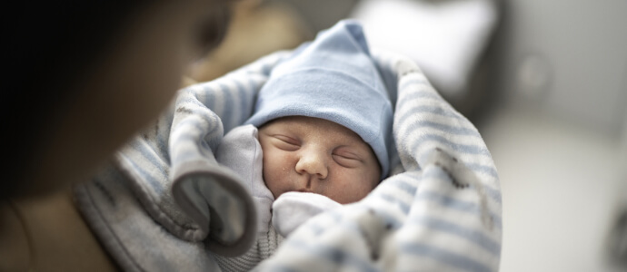 Newborn baby boy swaddled in hospital blanket