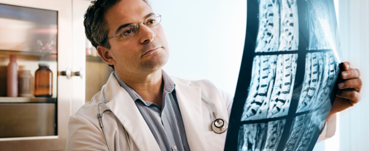Doctor examining and x-ray showing spinal cord injuries