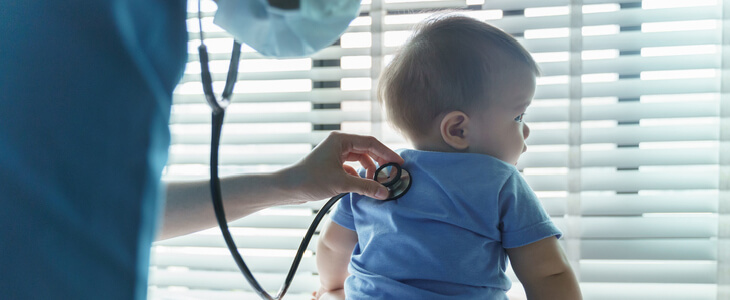 doctor putting stethoscope onto baby's back
