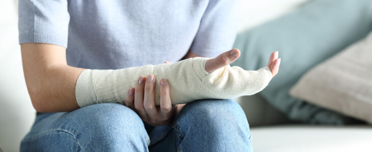 Person sitting with arm that is in a cast over their lap